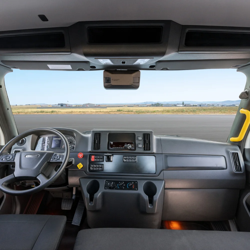 Freightliner M2 112 Plus Series interior showcasing the steering wheel, controls, and spacious front view
